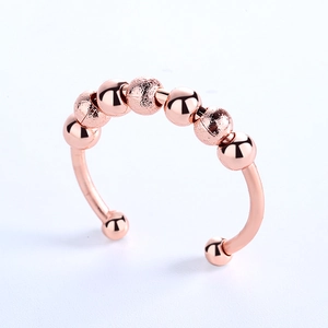 Adjustable rose gold anxiety ring with eight rotating beads and polished finish