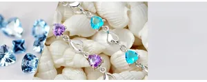 Détail macro du bracelet argenté orné de cœurs en cristal violet et bleu