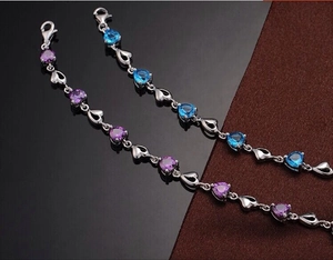 Détail de bracelets en cœur plaqués argent avec cristaux de zircone bleus et violets