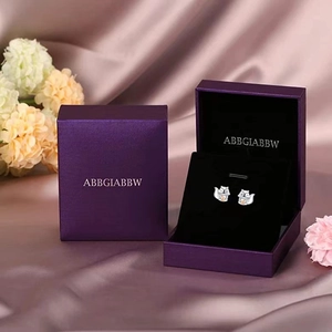 Creative squirrel earrings with golden pinecone in a purple branded gift box