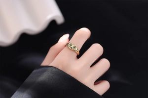 Vue détaillée d'une bague coeur dorée avec une illustration de visage qui pleure
