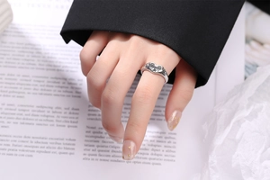 Gros plan d'une bague cœur en argent vintage avec texture antique sur la main du mannequin