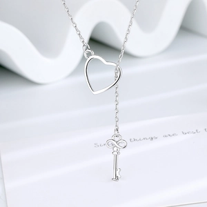 Minimalist adjustable silver key pendant necklace with heart slide on wave display