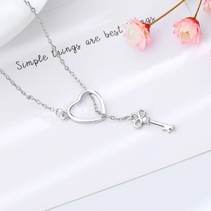 Silver adjustable key and heart pendant necklace with infinity symbol on white background