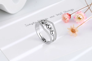 Vue macro d'une bague anti-stress argentée avec perles rotatives et anneaux texturés