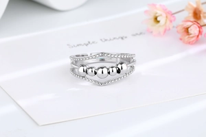 Détail des perles rotatives en argent et des couches ondulées sur la bague réglable