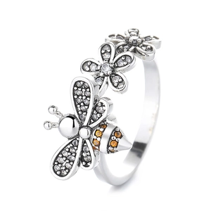 Rotating bee daisy spinner ring in silver with orange and white zircon stones