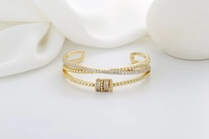 Macro shot of double-layered gold cuff bracelet with rotating micro-pave zircon charms