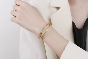 Close-up of layered gold bracelet with pavé cubic zirconia on professional model