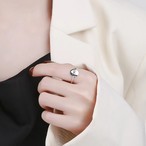 Minimalist silver ring with round engraved initial disc worn on finger for fashion look