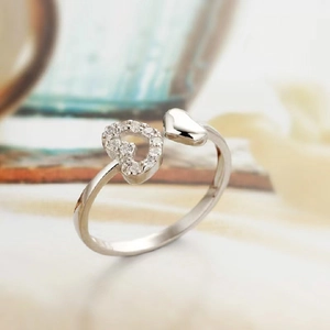 Macro detail of silver open ring featuring intertwined polished and zircon pavé hearts