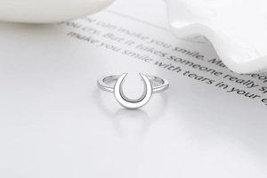 Detail shot of a silver minimalist crescent moon ring on a decorative aesthetic card