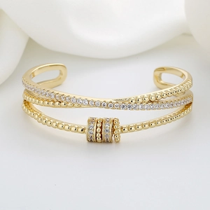 Three-layer gold open bangle with cubic zirconia pave and spinning beads detail