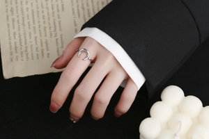 Minimalist silver moon-shaped open ring shown on hand with elegant aesthetic props