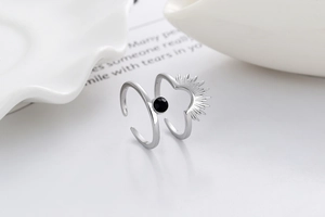Macro shot of double-layer open ring featuring a black stone and sunburst motif
