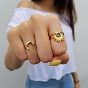 Minimalist gold moon and sun ring set with black gemstone on a female finger