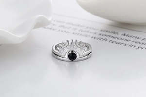 Macro detail of bohemian silver sunburst and minimalist rings with black zircon