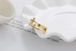 Détail de la bague double croix dorée ornée de strass brillants pavés