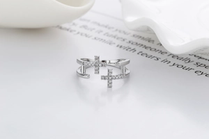 Vue détaillée d'une bague double croix argentée ornée de strass étincelants