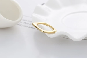 Nahaufnahme eines minimalistischen goldenen quadratischen Rings mit polierter Oberfläche