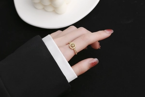 Détail d'une bague Saturne dorée avec design d'orbite céleste sur un doigt