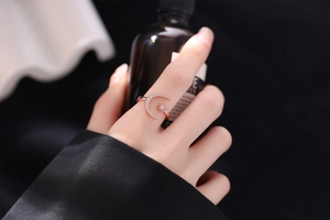 Detail of rose gold moon and star ring with sparkling zircons on a woman's finger