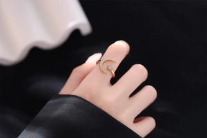 Close-up of adjustable golden crescent moon and star ring with sparkling zircons