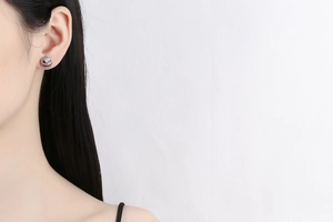 Close-up of Jack Skellington skull stud earring with white zircons and red enamel smile