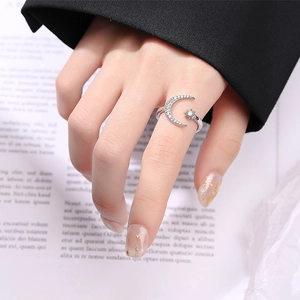 Adjustable silver crescent moon and star ring with sparkling diamonds worn by a model