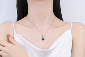 Close-up of vintage punk skull and cross pendant necklace in silver finish on a model