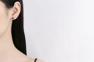 Close-up of a model wearing retro silver gothic skull earrings with a metallic finish
