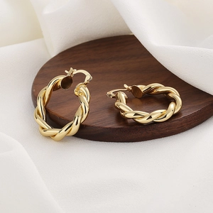 Élégantes boucles d'oreilles créoles torsadées dorées avec design tressé géométrique