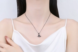 Collier pendentif crâne noir gothique en métal mat porté par un mannequin sur une chaîne