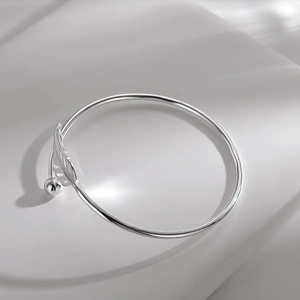 Polished silver feather cuff bracelet for women featuring leaf design and round bead