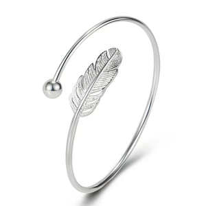 Detail shot of silver feather bangle with polished bead tip on white background
