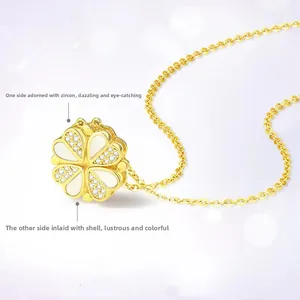 Macro detail of gold clover pendant featuring white shell and pavé cubic zirconia