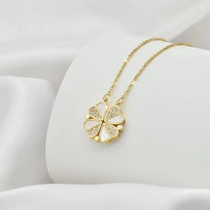 Close-up of gold clover necklace with mother of pearl and paved crystal details