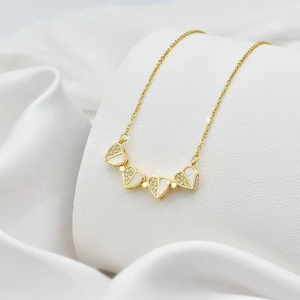 Macro view of clover necklace with white mother of pearl and pave crystals on silk