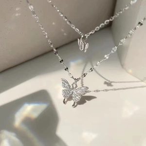 Macro shot of silver butterfly pendant with pavé cubic zirconia and shiny delicate chain