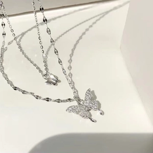 Close-up of double-layer necklace featuring sparkling pavé crystal butterfly pendants