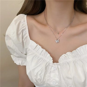 Detail of silver double-layer butterfly necklace with sparkling rhinestones on neck