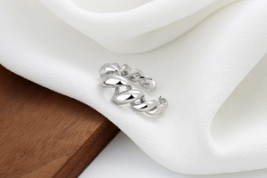 Macro shot of silver twisted rope ring with high-polish finish on draped fabric