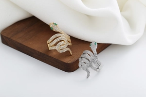 Dettaglio dell'anello a serpente con diamanti pavé, occhi di gemme verdi e corpo a spirale