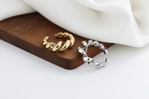 Detail of twisted rope hollow rings in gold and silver finish with adjustable open band
