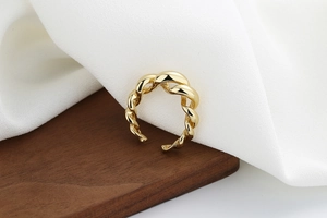 Macro detail of gold-plated twisted rope ring showing polished texture and open structure