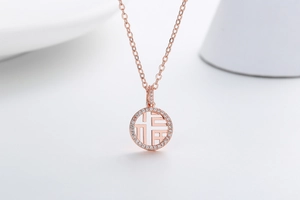 Macro detail of rose gold Fu pendant with pave-set crystals and hollow circular design