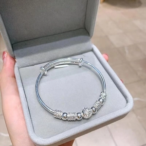 Bracelet jonc argenté ajustable avec perles gravées présenté dans un écrin gris