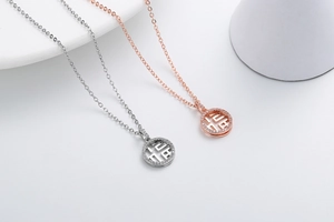 Detail of silver and rose gold necklaces with hollow pendants and micro-inlaid diamonds