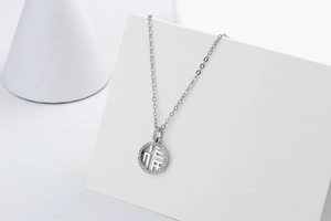 Detailed close-up of a silver pavé diamond round pendant with hollow Fu character design