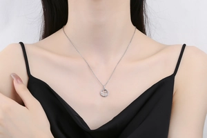 Detailed view of hollow Fu character pendant with micro-pave crystals on a silver chain
